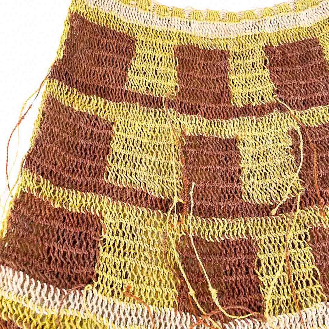 Close up on woven body of brown and yellow thick weave bilum.