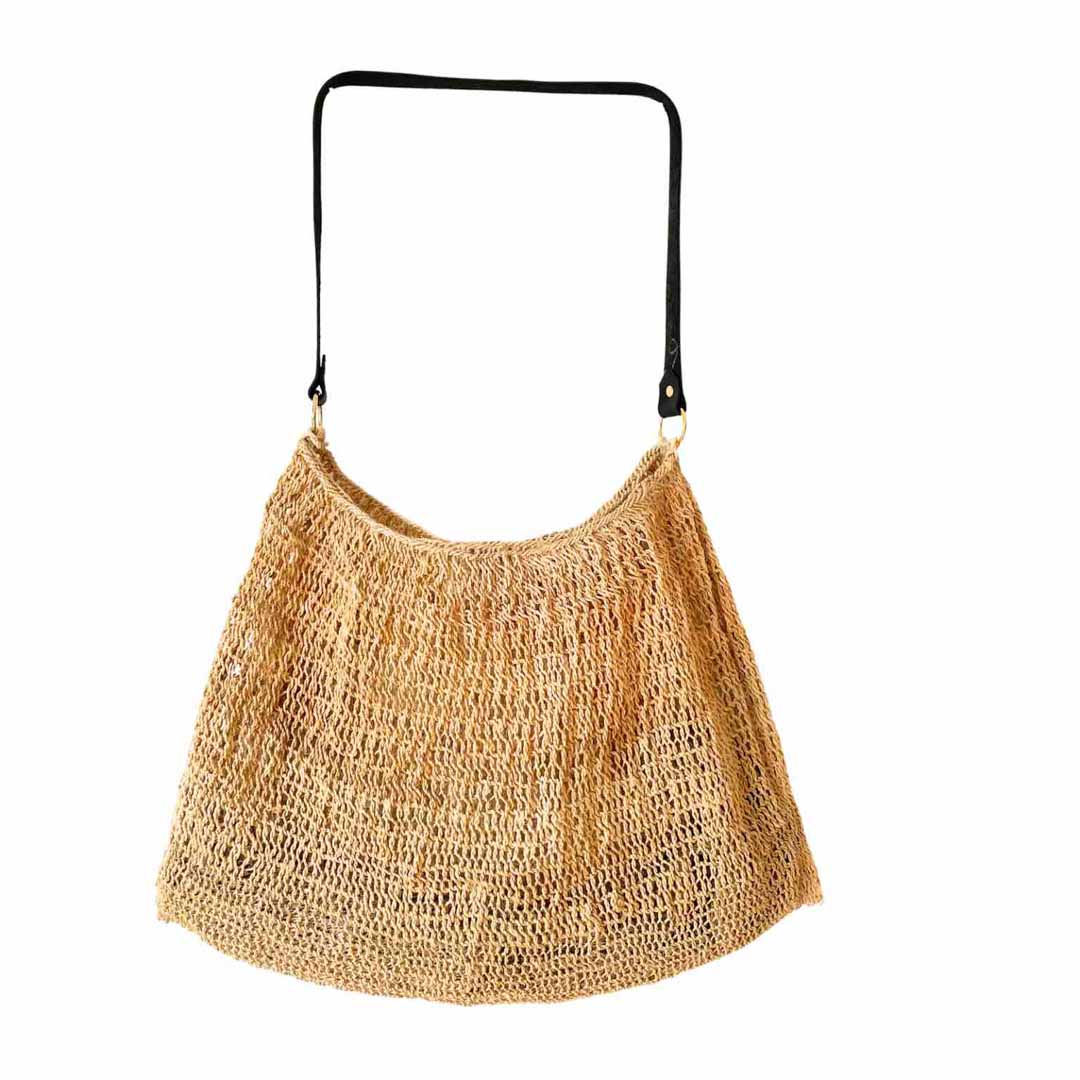 Plain natural fibre bilum with leather strap hanging on a white background.