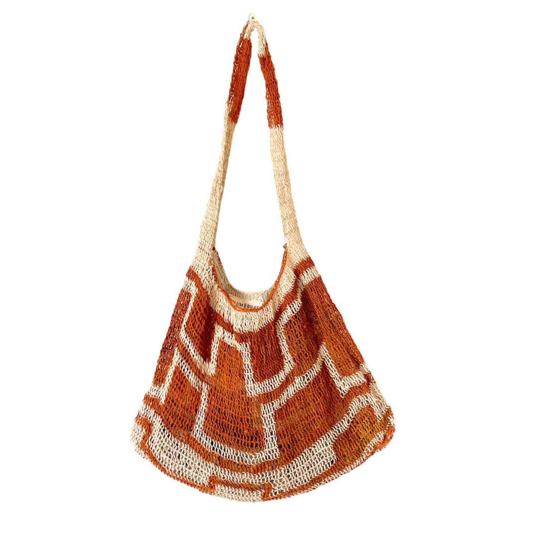 Burnt orange and white patterned natural fibre bilum bag.