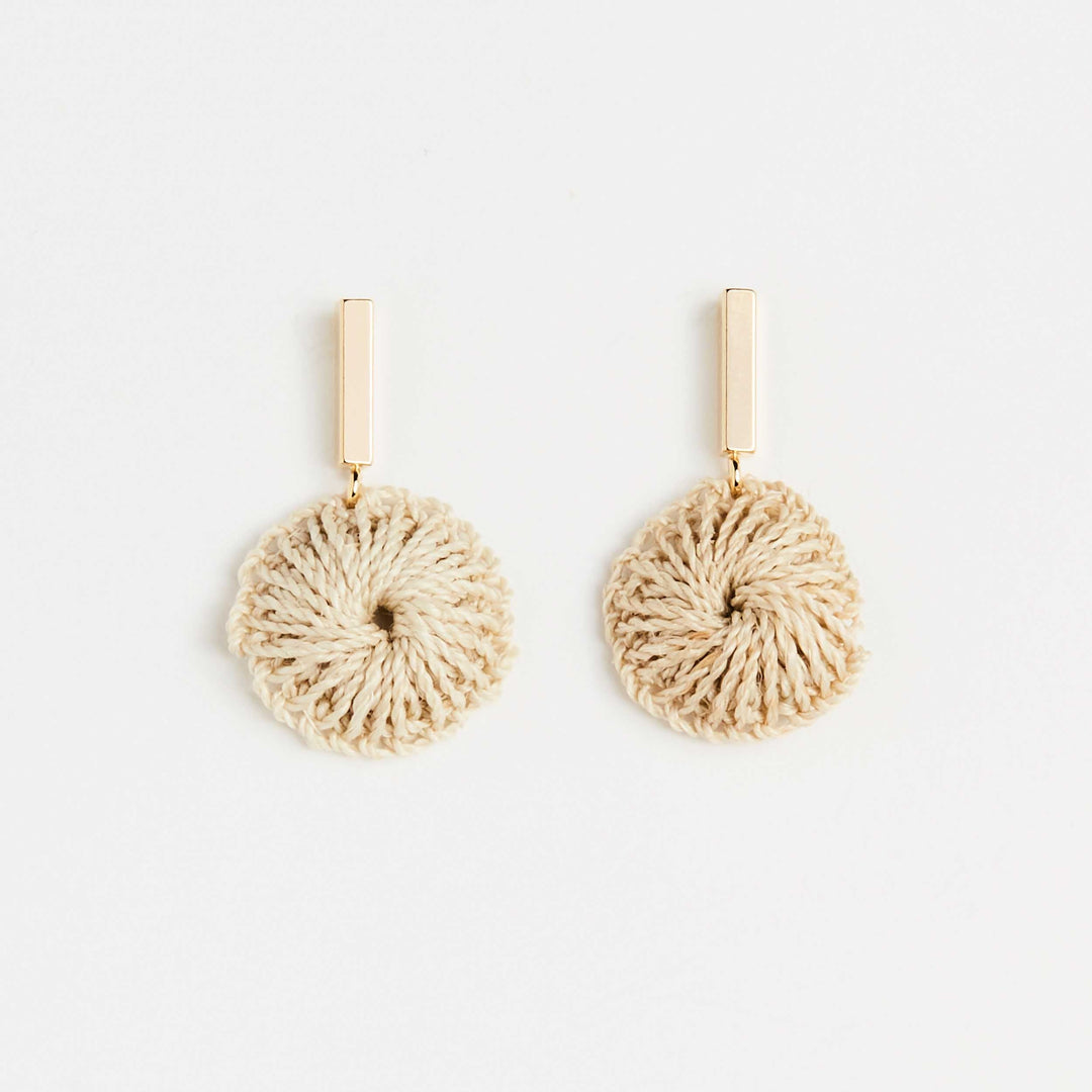 Bilum and Bilas gold bar earring with dangling handwoven natural fibre disc front view