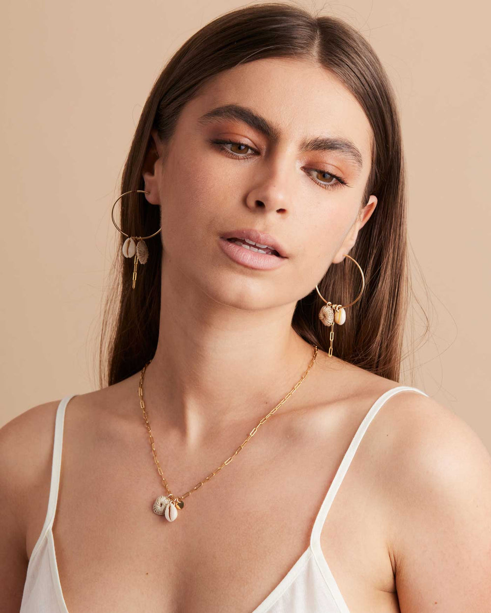 Model glancing wearing Bilum and Bilas gold filled paperclip chain necklace with pacific charms