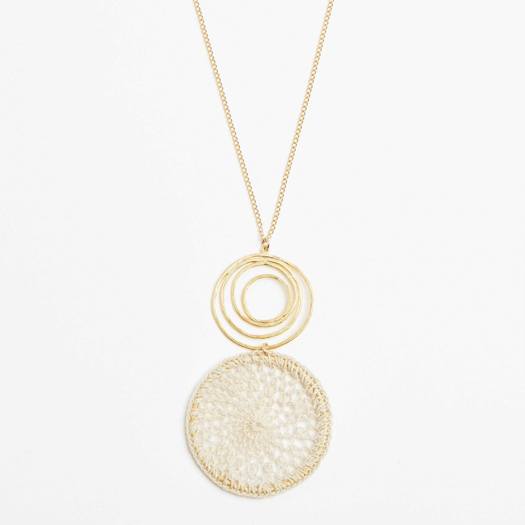 Gold filled fine chain necklace with gold swirl and natural fibre woven disc pendant close view
