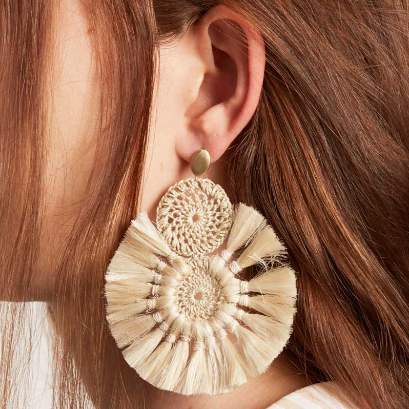 Model wearing Bilum and Bilas Sandei statement earring. Earring with double woven disc with natural fibre tassels.