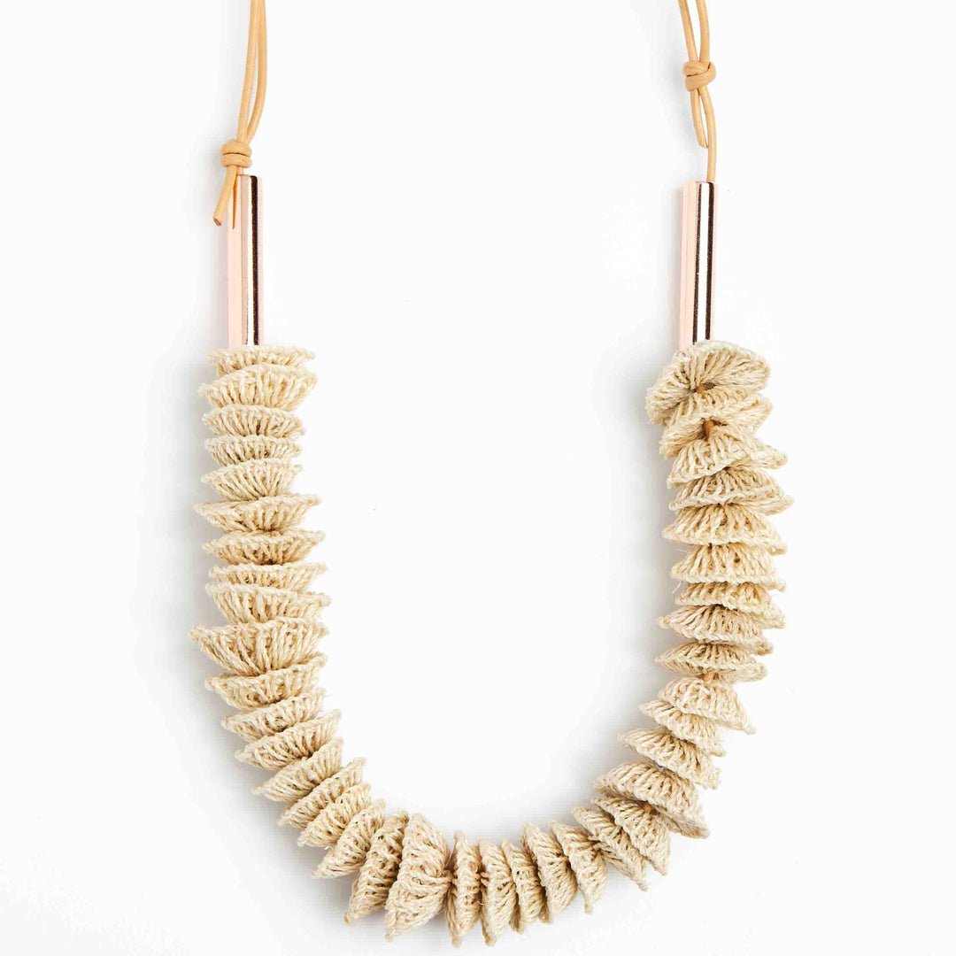Close up view of the Bilum and Bilas Lewa textile necklace with stacked handwoven and rose gold bead