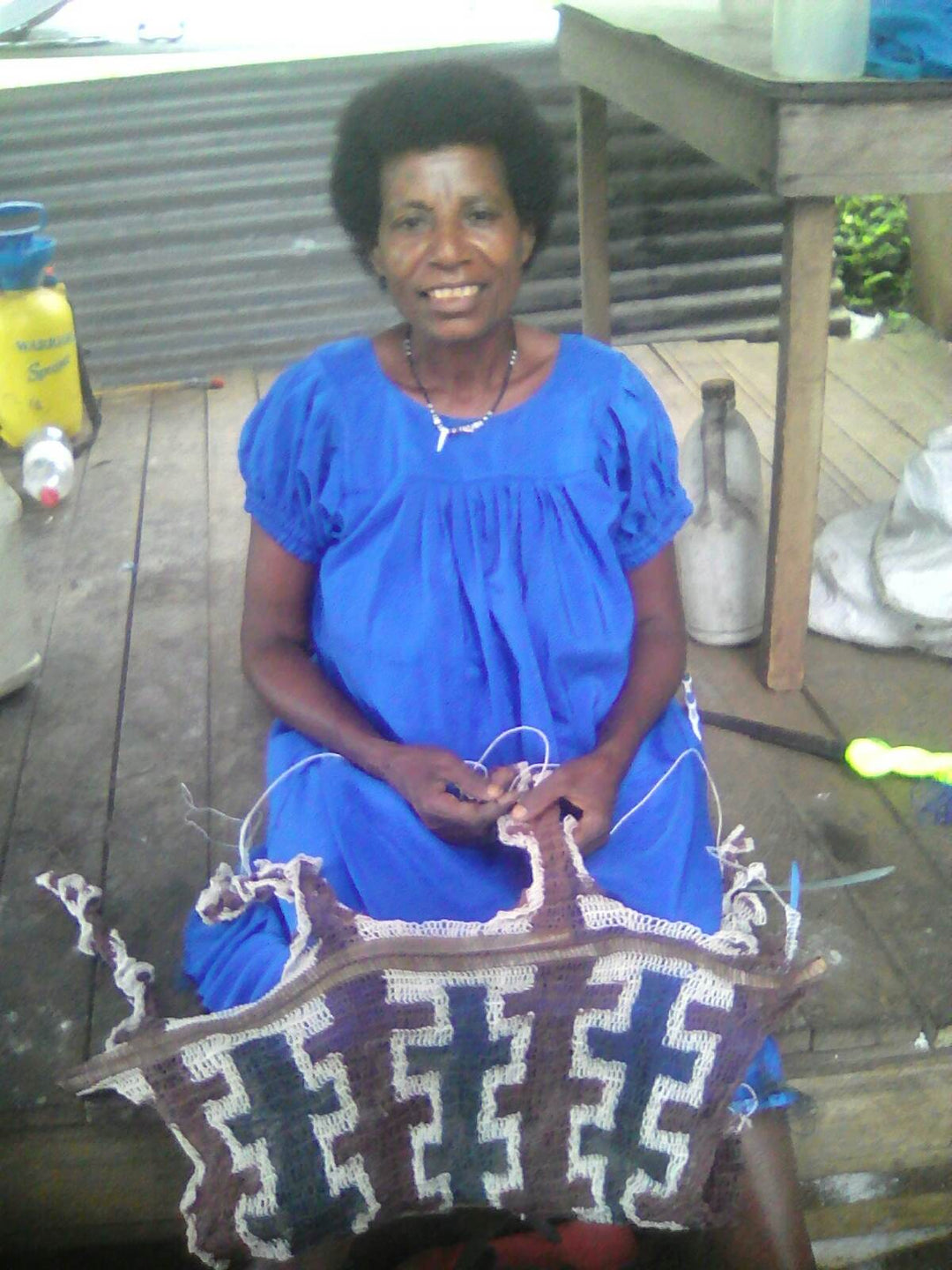 Papua New Guinean weaver Madelyn Alok handwaving a natural string bilum