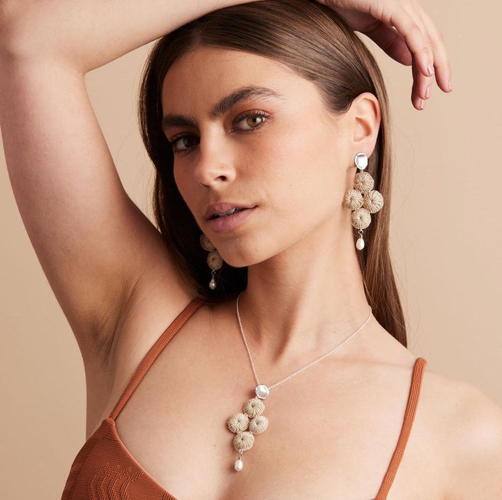 Silver Malalo Breeze earrings with pearl and natural fibre on model with matching necklace