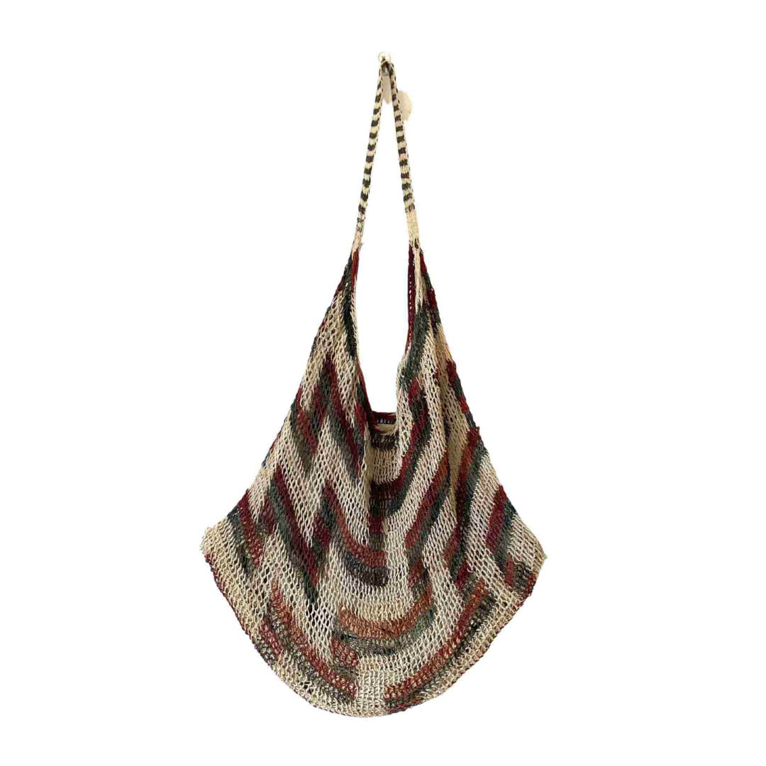 Zig zag patterned string bilum from Morobe Province in Papua New Guinea hanging on a white background.