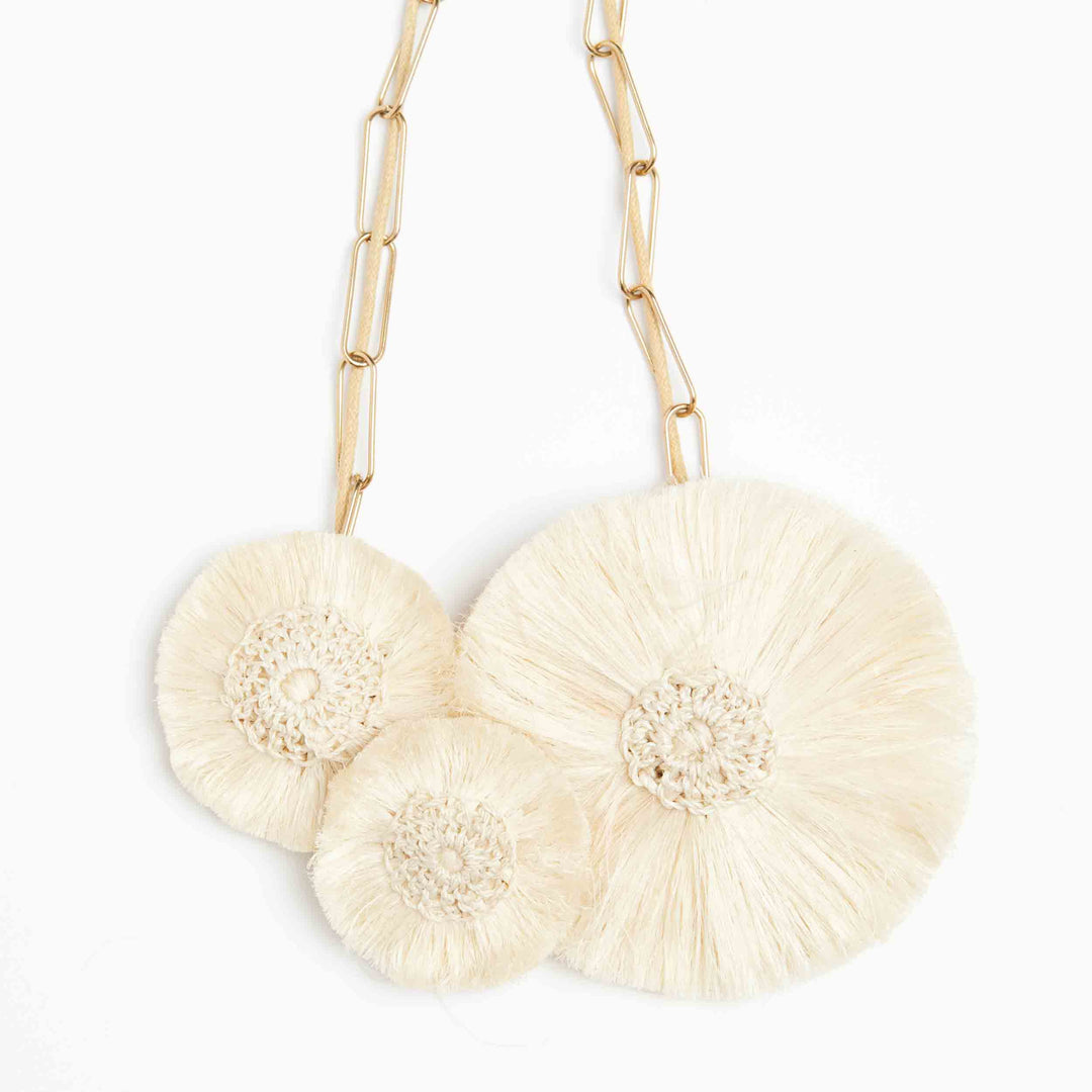 Close up of statement woven hibiscus necklace pendant.