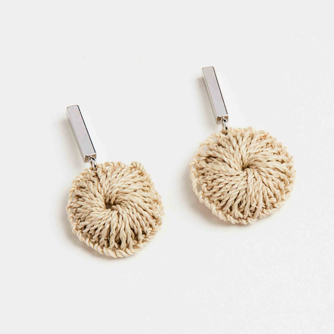 Bilum and Bilas silver bar earring with dangling handwoven natural fibre disc front angled view