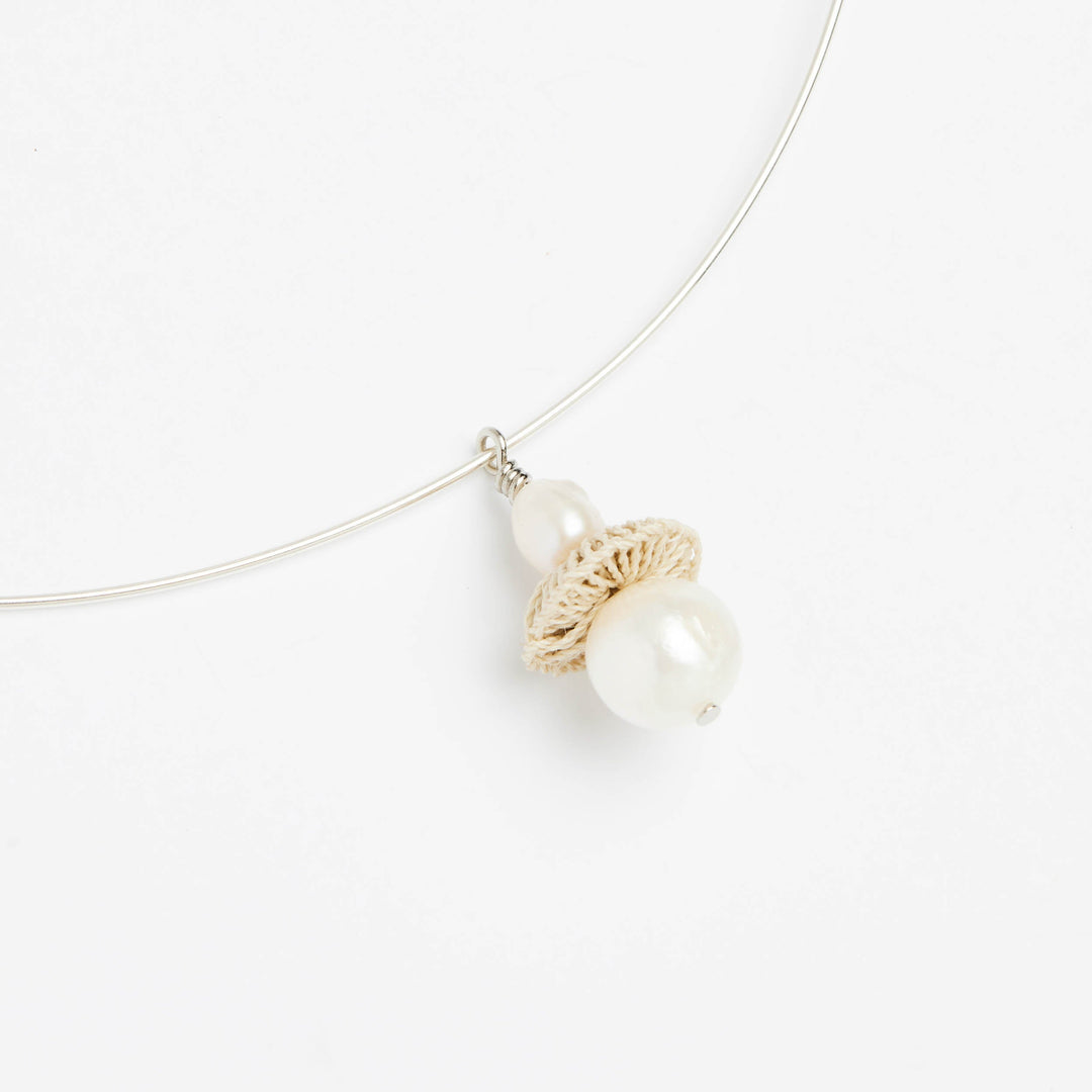 Side angle of sterling silver choker pendant with pearl and woven natural fibre disc