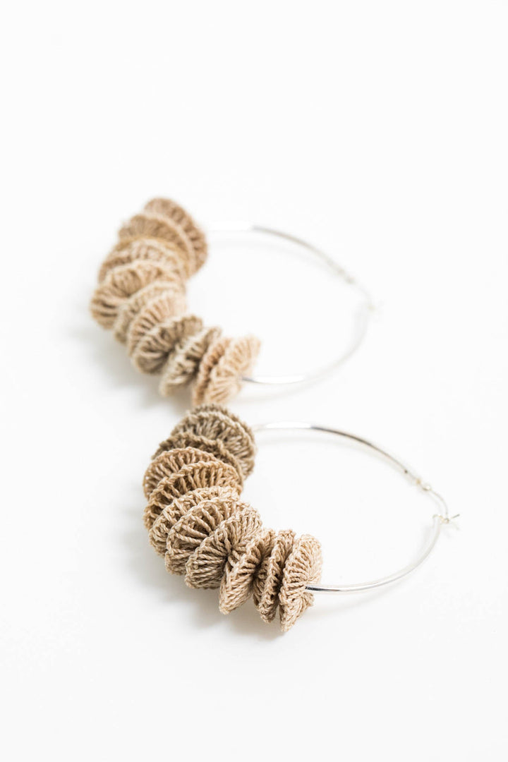 Side angle view of Bilum and Bilas sterling silver endless hoop earrings with textile bead stacks full view