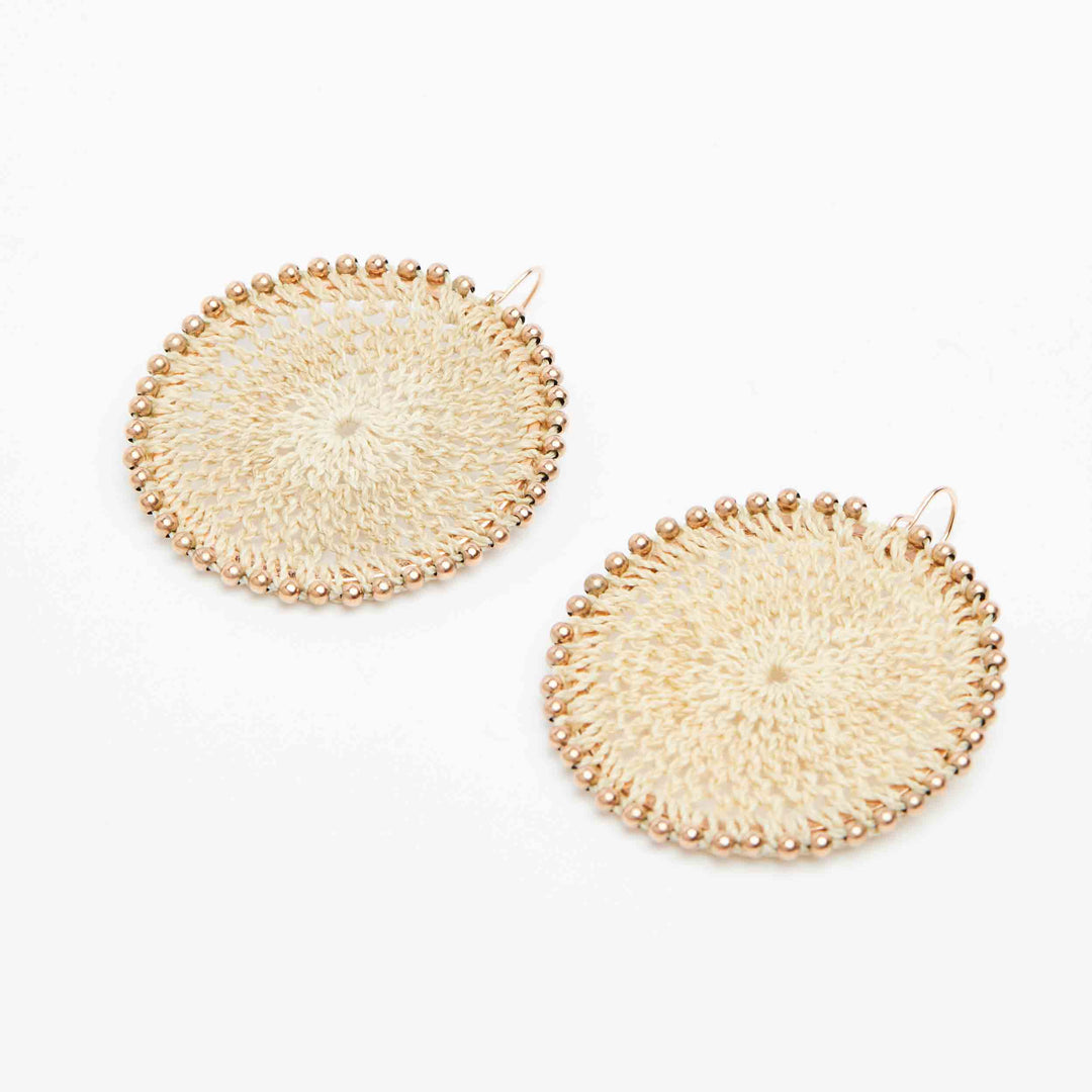 Side angle of Bilum and Bilas rose gold beaded woven disc earrings with ear hooks